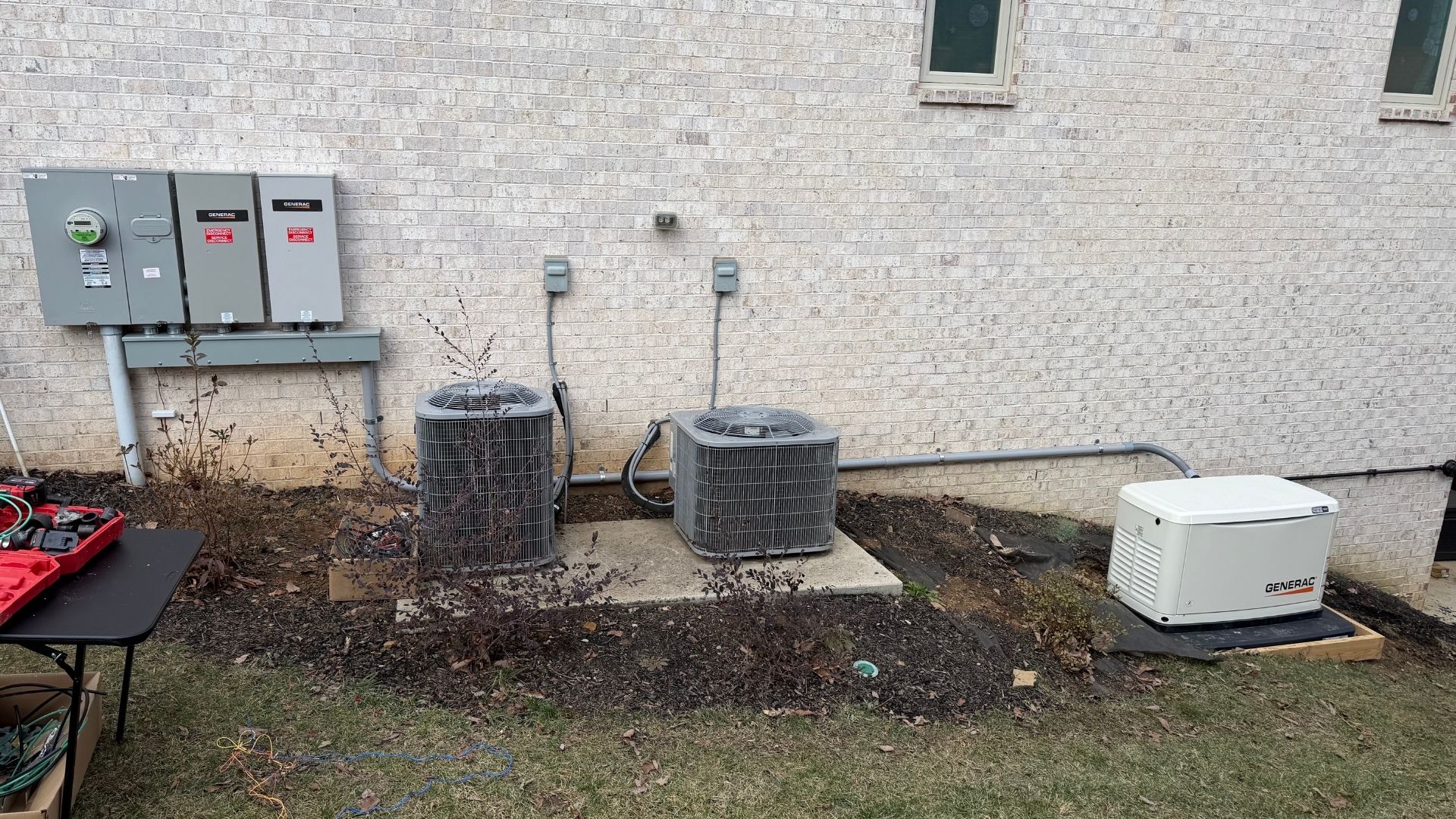 Generac generator and air conditioning units next to brick house wall